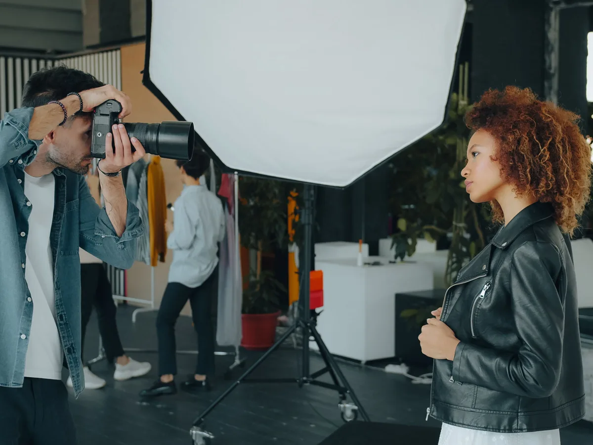 Fotograf fotografiert ein Model im Studio mit Softbox-Beleuchtung